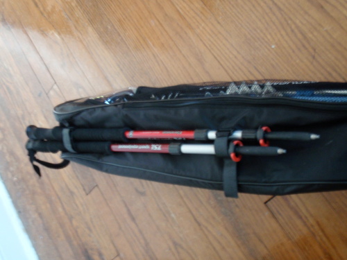 Snowshoes in storage bag with poles for handles.